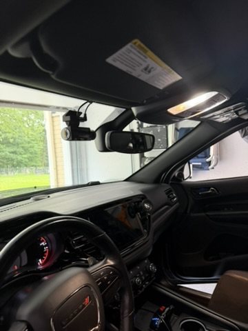 Installed dash cam positioned behind a rear-view mirror