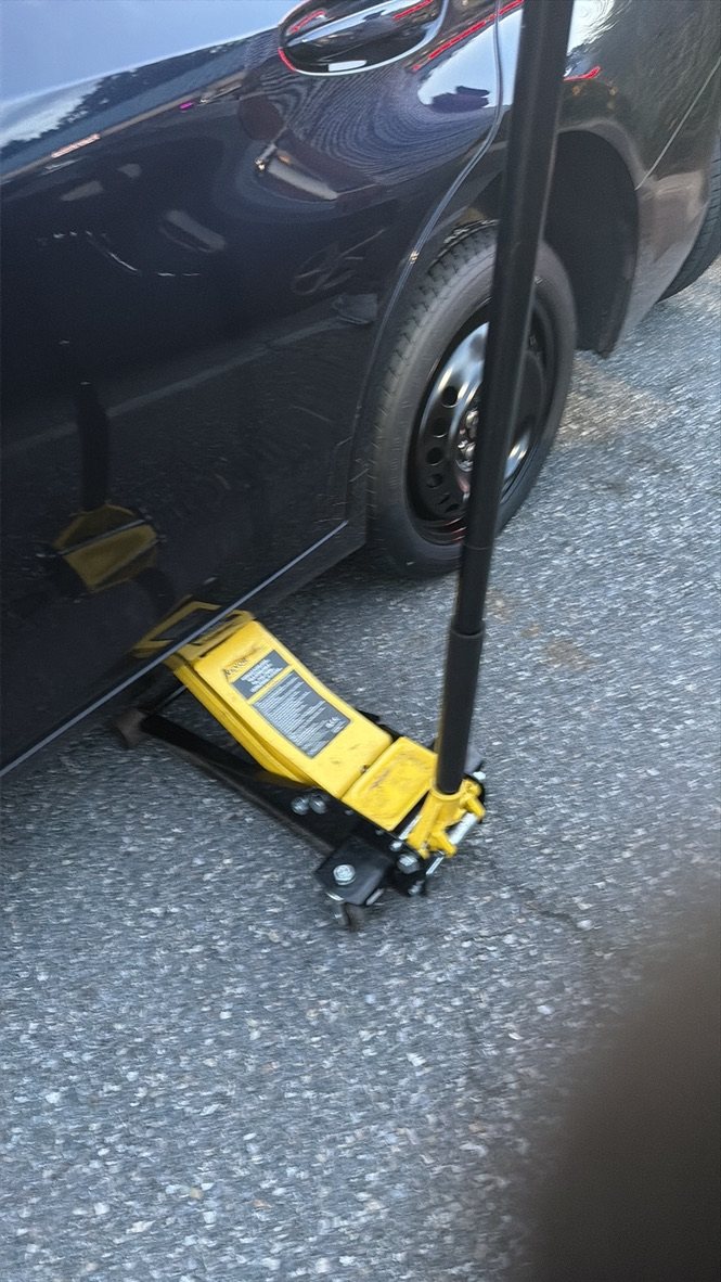 Vehicle wheel being lifted for a mobile tire-service visit