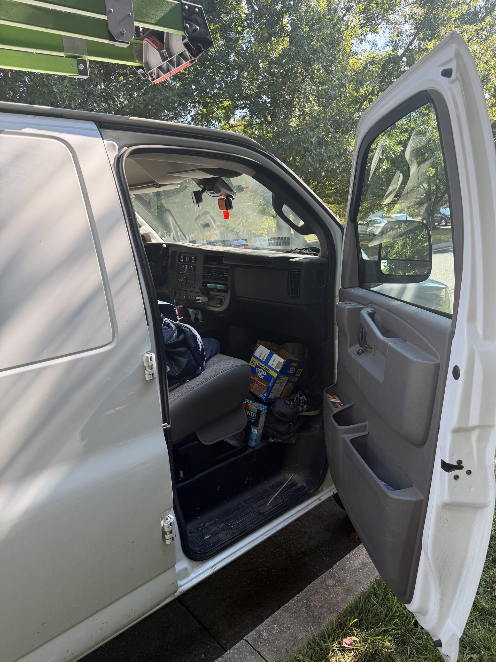 White Chevrolet Express van with its passenger door open after lockout assistance in Owings Mills