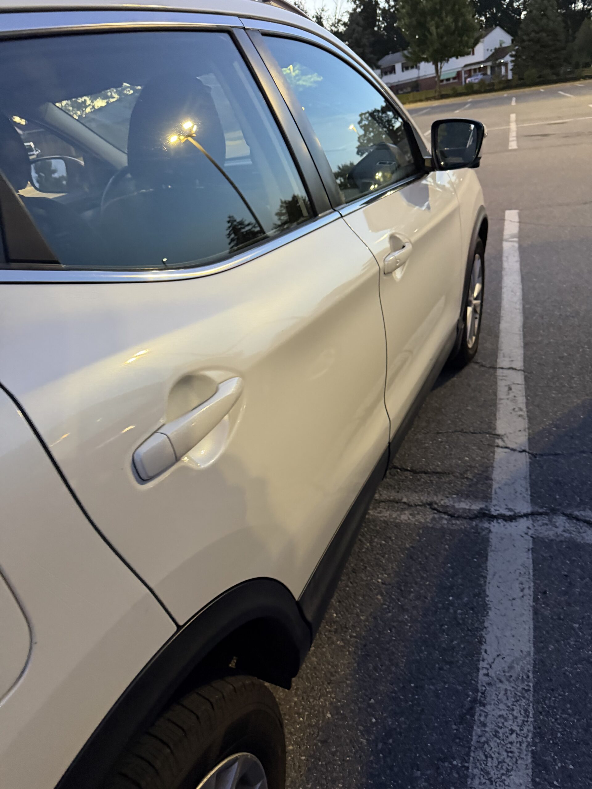 Side view of a white Nissan Rogue with its road wheel still fitted during the Security Boulevard tire callout