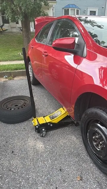 Toyota Camry raised safely for flat tire repair during a Laurel Maryland mobile service visit