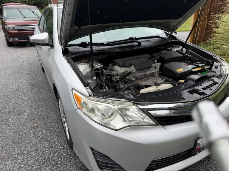 Auto Tools Mart mobile battery replacement on a Toyota Camry in rainy Pikesville, Maryland