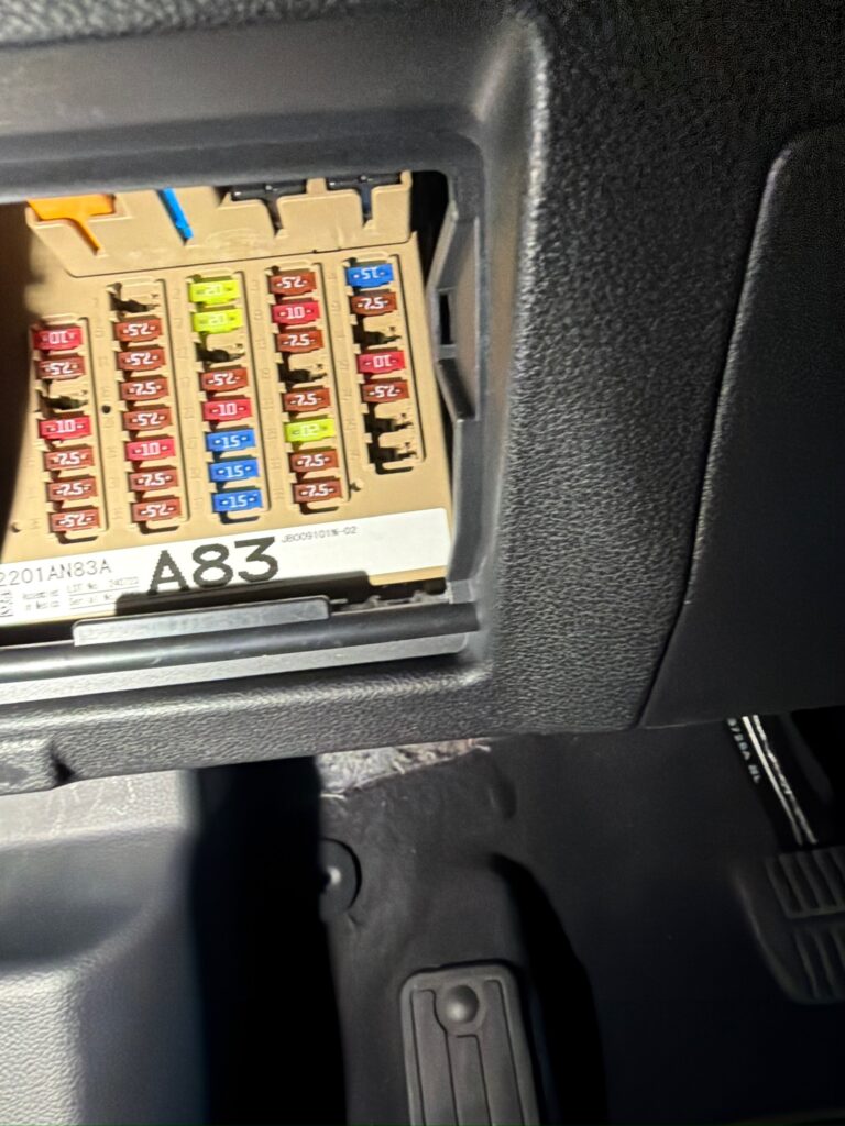 Open Subaru Outback interior fuse panel showing rows of blade fuses and the A83 identification label.